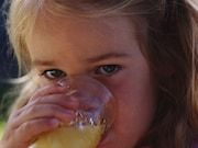 Headshot of girl drinking juice in glass