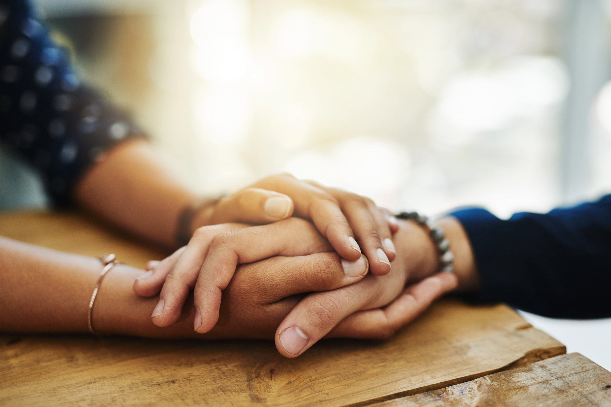 Closeup shot of two people holding hands in comfort