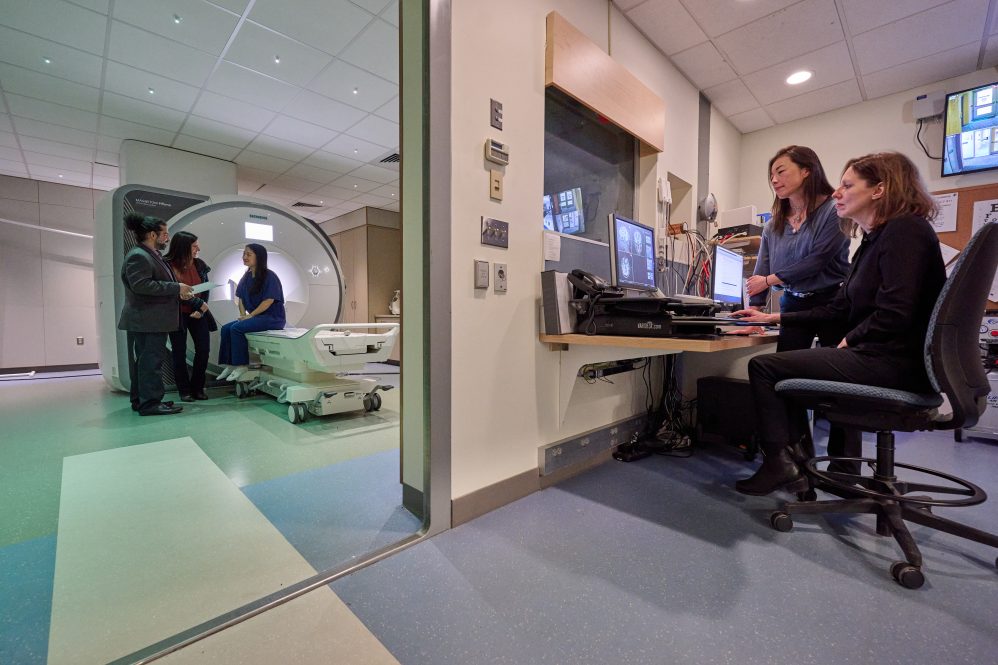 Arash Esmaili Zaghi, left,Fabiana Cardetti, and Jie Luo, with the fMRI, and Fumiko Hoeft, Nicole Landi, in the control room at the UConn Brain Imaging Research Center. (Peter Morenus/UConn Photo)